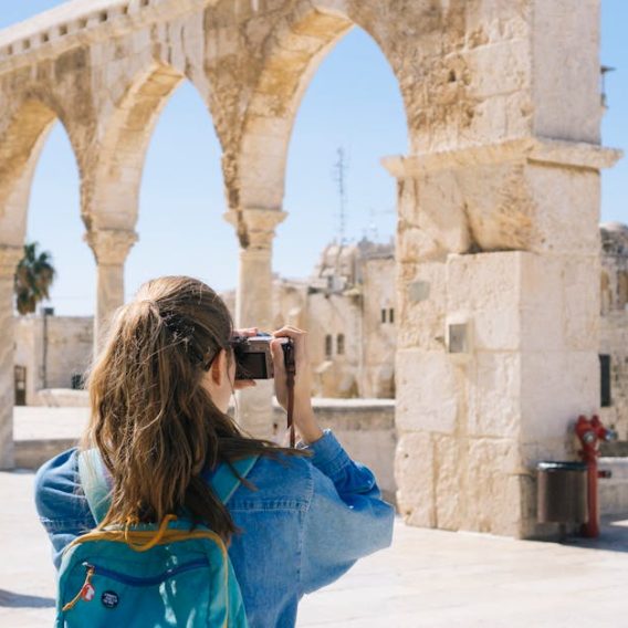 pexels-photo-2087391-2087391 A tourist photographs the ancient stone arches in Jerusalem's Old Town, capturing the essence of travel and history.